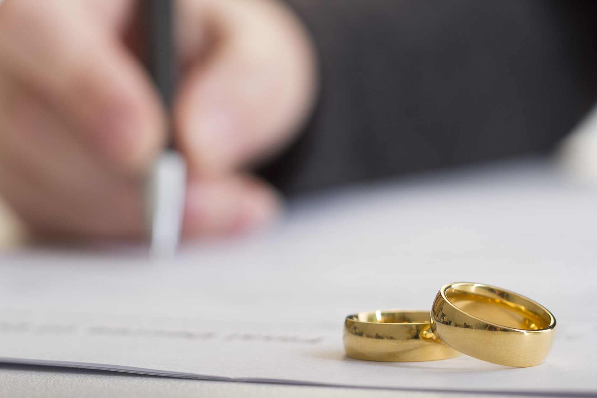 Divorce concept. Hands of wife, husband signing decree of divorce, canceling marriage, legal separation documents.